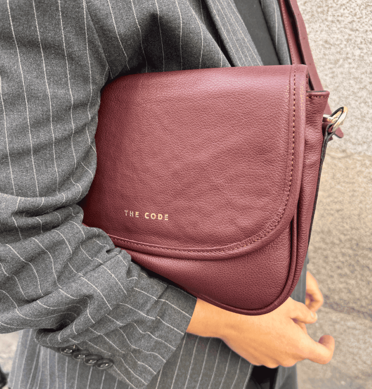 Interior del bolso Claudia de The Code en burdeos, forrado en textil negro con bolsillo sellero y acabados de calidad.