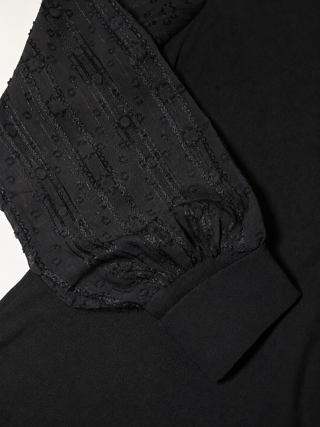 Detalle de la manga transparente de gasa negra con bordados geométrico, hilos de lúrex y puño ancho ,camiseta Ciudad Real de Lylu.