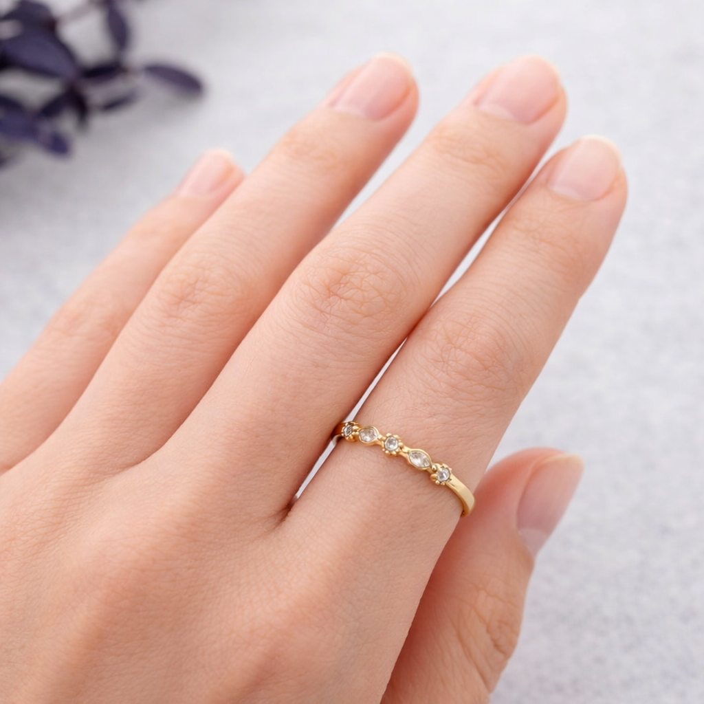 Detalle del anillo Astra de acero dorado con circonitas blancas y acabado mate labrado