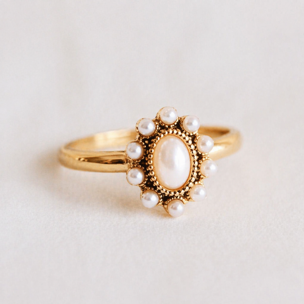 Anillo Elara vintage dorado con piedra blanca ovalada y detalle perlado