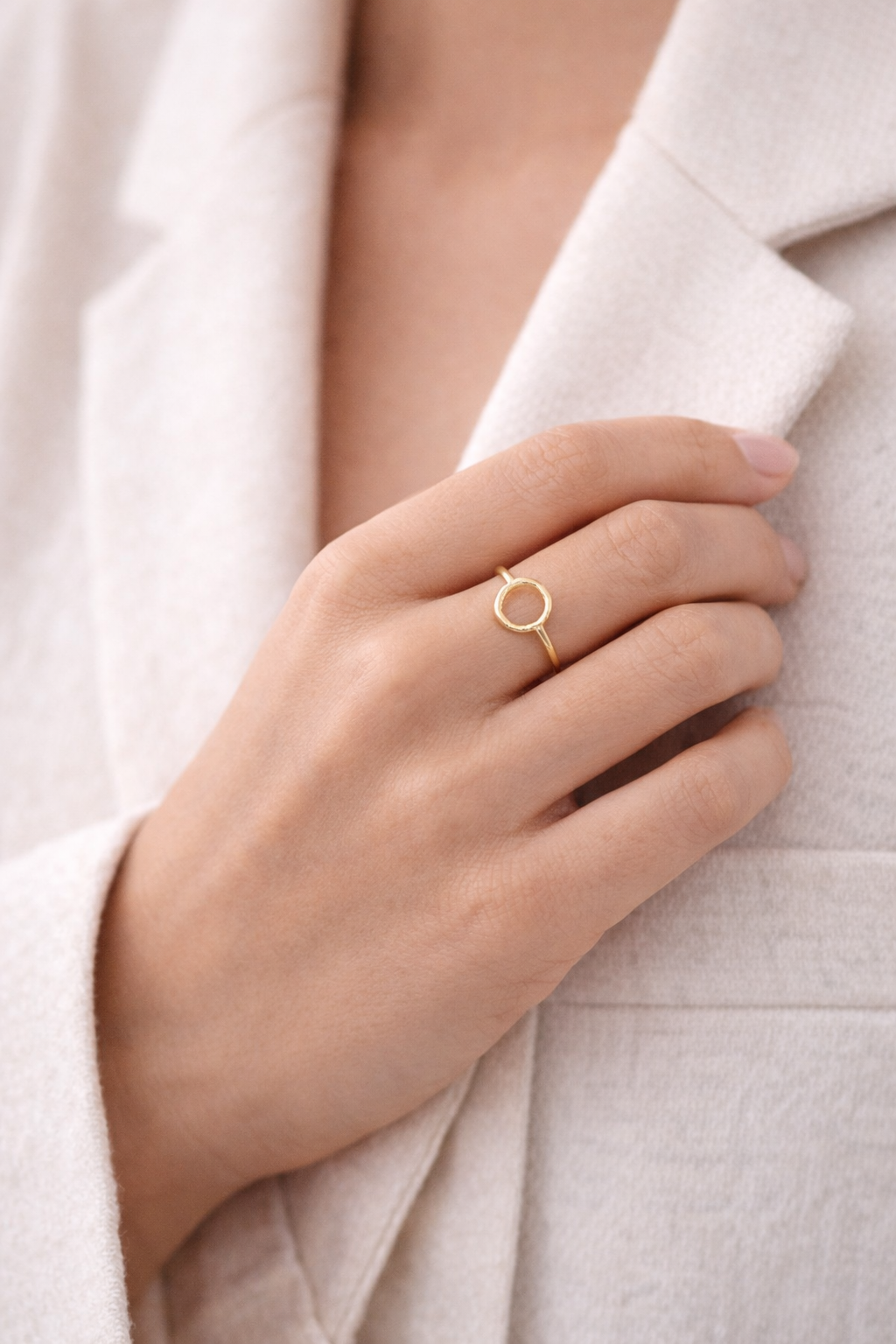 Anillo Orbe de acero dorado con círculo central mostrado en la mano