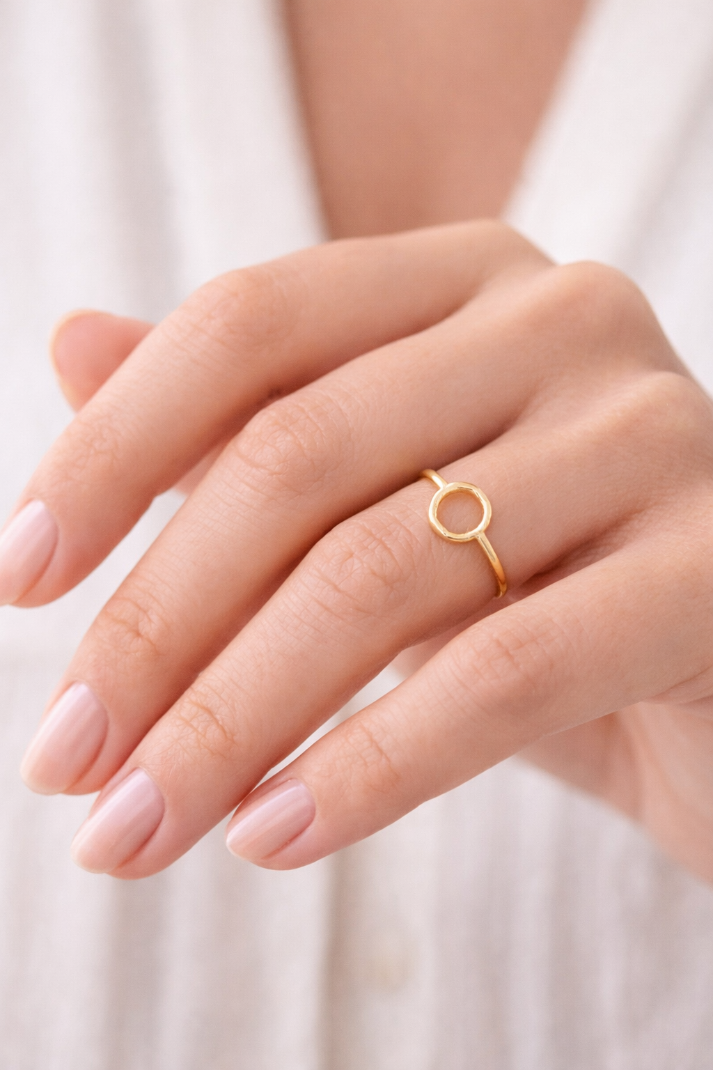 Detalle del anillo Orbe dorado con diseño circular minimalista y aro labrado