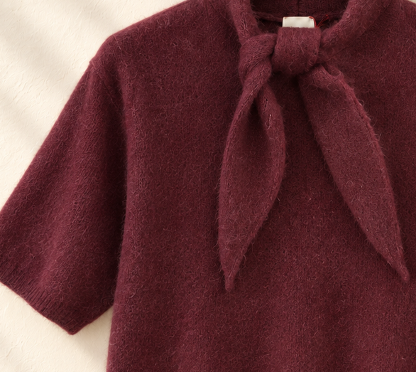 Detalle de la lazada en el cuello y tejido mullido del jersey Claudine en burdeos