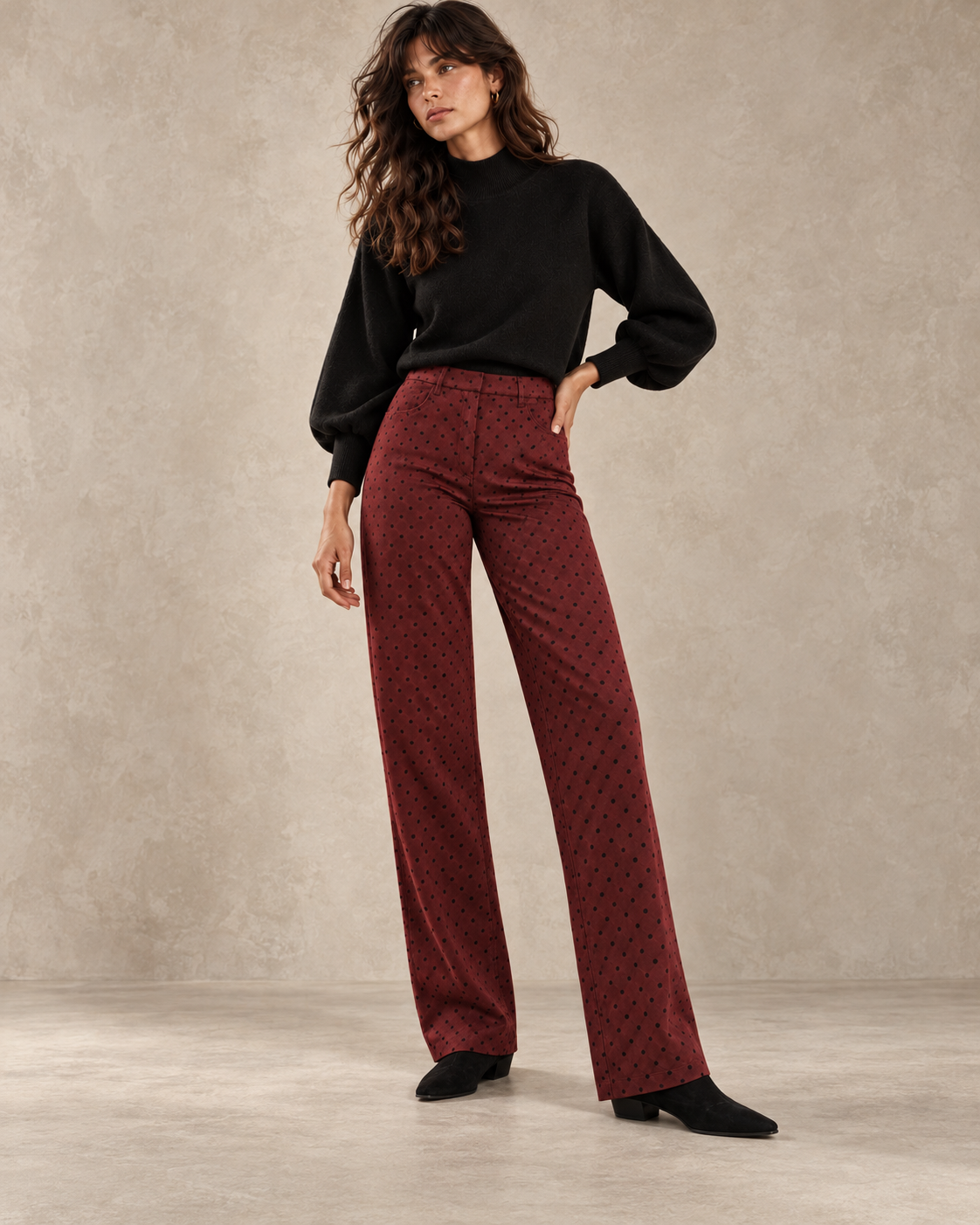 Modelo con pantalón San Sebastián de antelina burdeos y topos negros de LYLU, combinado con jersey negro