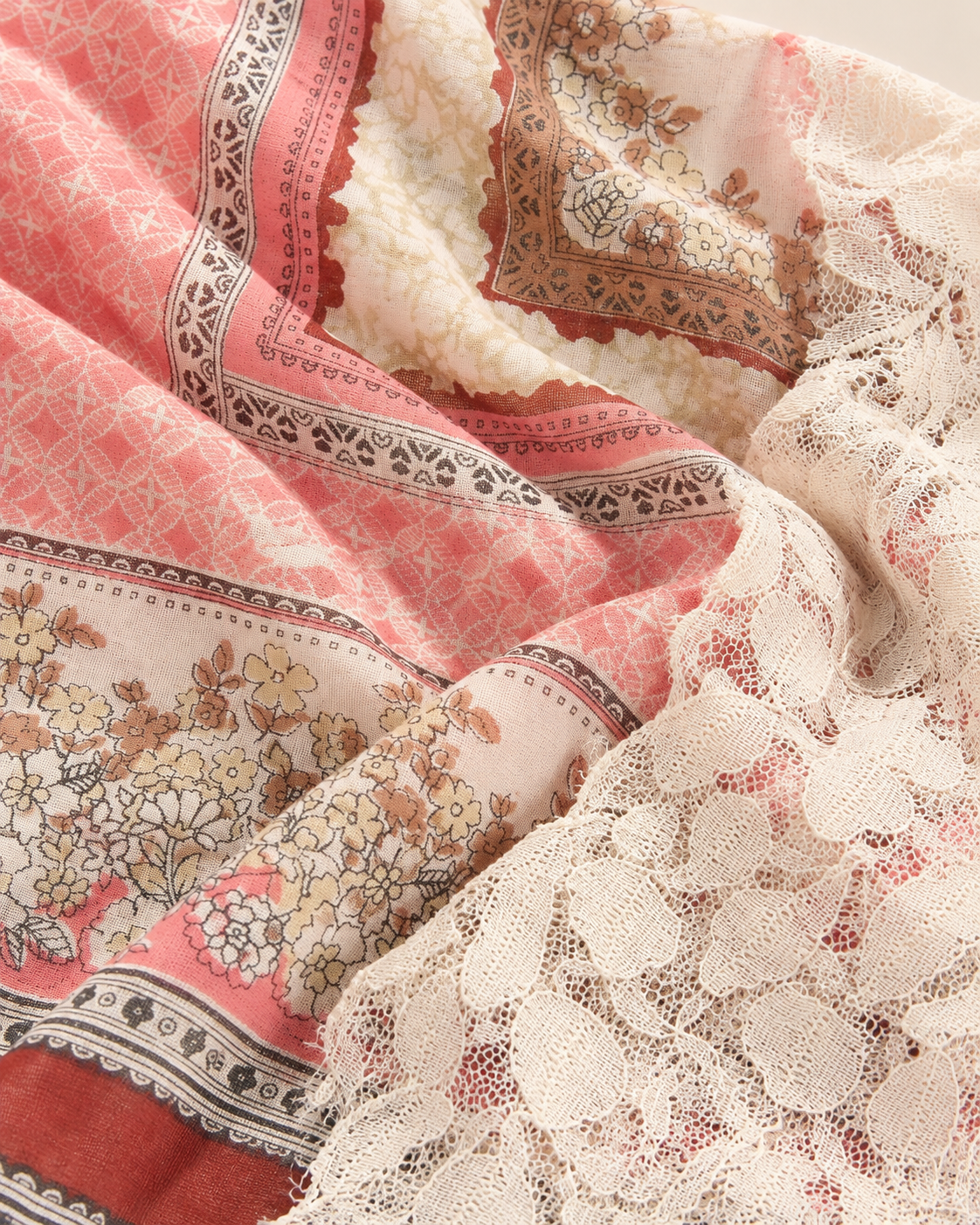 Detalle del tejido estampado, encaje blanco y tonos burdeos del pañuelo Catalina
