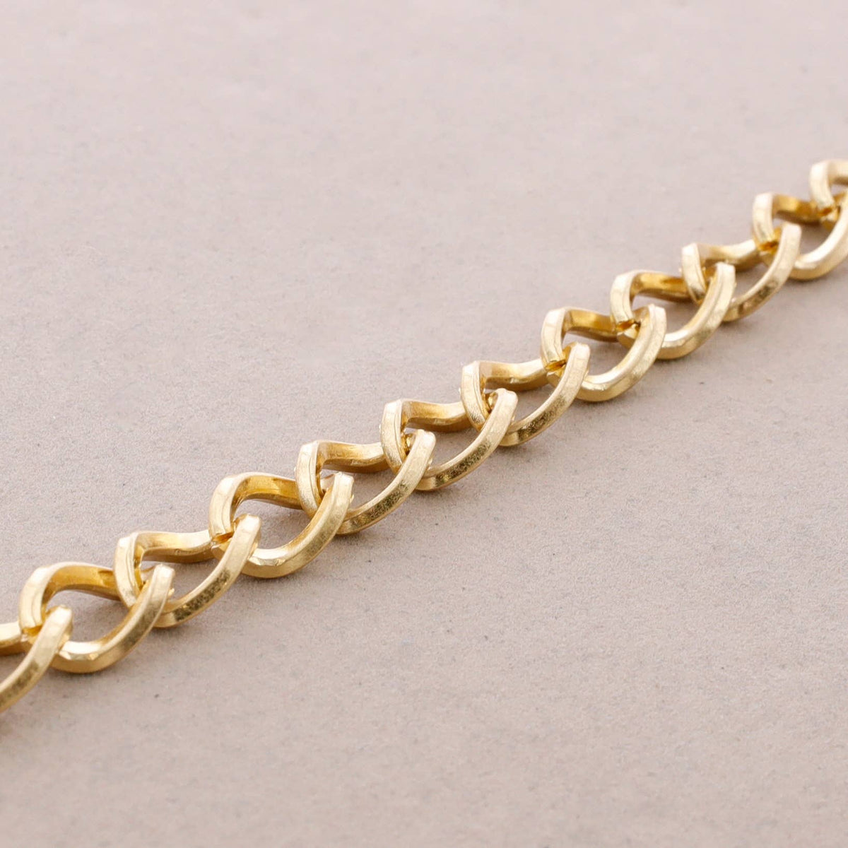 Detalle de los eslabones grandes de la pulsera Kinga en acero dorado mate