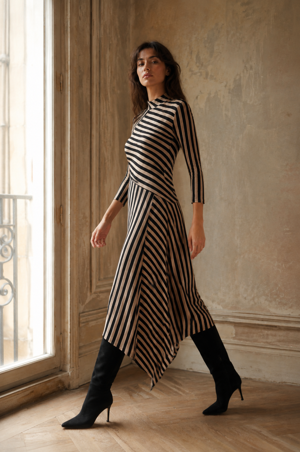 Vestido de rayas midi asimétrico Manzanares de LYLU visto de perfil mientras la modelo camina